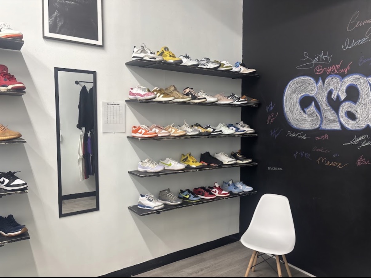 Sneaker shelves next to the signed chalk Gravity wall and mirror
