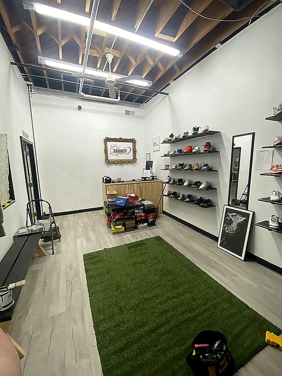Inside Gravity Sneakers — shoe shelves, turf rug, and the counter at the Farmington shop